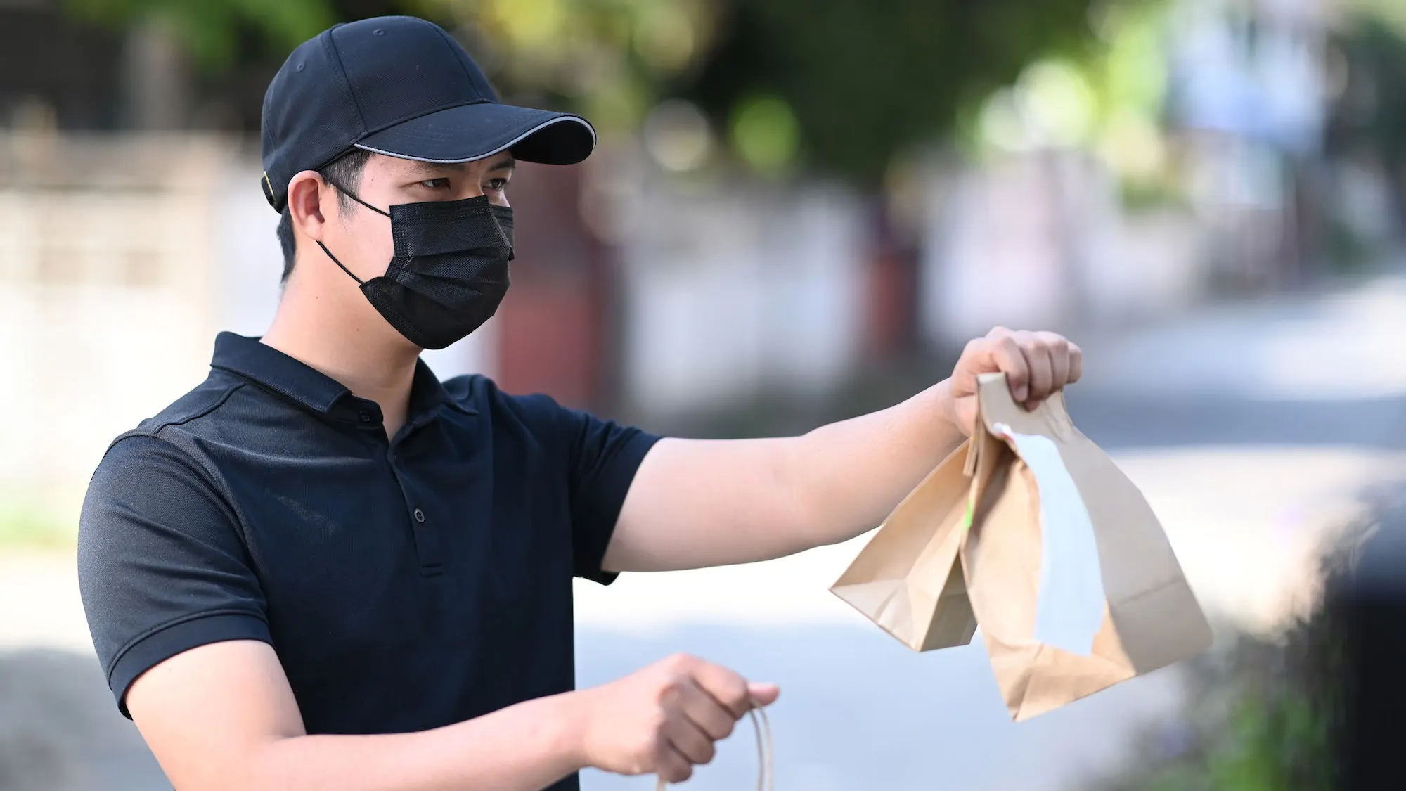 delivery-man-in-protective-mask-delivering-food-to-customer-at-doorway-